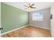 Bright bedroom features hardwood floors, a ceiling fan, a large window, and neutral paint for a cozy atmosphere at 1232 Berganot Trl, Castle Pines, CO 80108