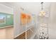 Well-lit hallway with hardwood floors and a modern light fixture offers access to various rooms in the house at 1232 Berganot Trl, Castle Pines, CO 80108
