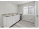 Basement bar area features granite countertops, white cabinets, a mini-fridge, and hardwood floors at 1232 Berganot Trl, Castle Pines, CO 80108