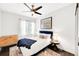Bright bedroom featuring white walls, a ceiling fan, and a plush bed with a blue headboard and throw at 1402 Meade St, Denver, CO 80204