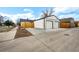 View of the two-car garage with white siding and concrete driveway, providing ample parking and storage at 1402 Meade St, Denver, CO 80204