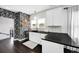 Stylish kitchen with floral wallpaper, white cabinets, black countertops, and open shelving at 1402 Meade St, Denver, CO 80204