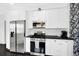 Bright kitchen with stainless steel appliances, white cabinets, and black countertops at 1402 Meade St, Denver, CO 80204
