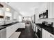 Modern kitchen features white cabinets, black countertops, and stainless steel appliances at 1402 Meade St, Denver, CO 80204