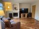Bright living area featuring a fireplace, large windows, and hardwood flooring at 14642 Williams St, Thornton, CO 80602
