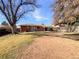 Large backyard with a covered patio and mature trees, perfect for outdoor entertaining at 3268 S Patton Ct, Denver, CO 80236