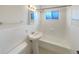 Bathroom featuring a pedestal sink, tub, and window at 3268 S Patton Ct, Denver, CO 80236