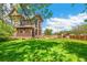 Expansive backyard with a stone home, green lawn, and outdoor seating area at 3520 Newton St, Denver, CO 80211