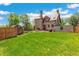 Large backyard featuring lush green grass and an exterior view of the home with a stone facade at 3520 Newton St, Denver, CO 80211