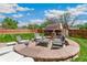Inviting backyard with a charming stone patio and a rustic outdoor fireplace with ample seating at 3520 Newton St, Denver, CO 80211