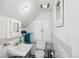 Cozy bathroom with white fixtures, blue tiled accents, and a storage cabinet above the commode at 3520 Newton St, Denver, CO 80211