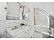 Modern bathroom features double sinks, marble tile, a shower with gold fixtures and a skylight at 3520 Newton St, Denver, CO 80211