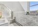 Charming bathroom with white marble tile, a skylight, brass shower fixtures, and a minimalist design at 3520 Newton St, Denver, CO 80211