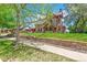 Beautiful exterior view of a stone house with lush landscaping and mature trees at 3520 Newton St, Denver, CO 80211