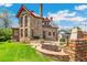 Beautiful stone home with a manicured lawn, patio, and inviting outdoor seating area at 3520 Newton St, Denver, CO 80211