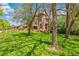 Picturesque view of a historic stone house surrounded by mature trees and a lush green lawn at 3520 Newton St, Denver, CO 80211