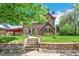 Charming stone house with a well-maintained lawn, stone stairs and brick retaining wall at 3520 Newton St, Denver, CO 80211