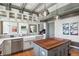 Bright kitchen featuring white cabinets, marble countertops, a wood island, and stainless steel appliances at 3520 Newton St, Denver, CO 80211