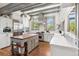 Bright kitchen featuring white cabinets, marble countertops, a wood island, and stainless steel appliances at 3520 Newton St, Denver, CO 80211