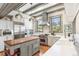 Bright, open kitchen with stainless steel appliances, white cabinets, and a butcher block island at 3520 Newton St, Denver, CO 80211