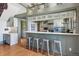 Modern kitchen with gray cabinets, stainless steel appliances, marble countertops, and breakfast bar at 3520 Newton St, Denver, CO 80211