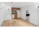 Basement kitchenette offers white appliances, minimalist wood cabinets, and sleek wood floors at 3520 Newton St, Denver, CO 80211