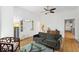 Bright living room with hardwood floors, a gray sofa, glass coffee table, and large white door at 3520 Newton St, Denver, CO 80211