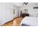 Bright bedroom boasts hardwood floors, a ceiling fan, walk-in closet, and a view to the ensuite bathroom at 3520 Newton St, Denver, CO 80211