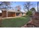 Well-maintained backyard featuring a covered patio and artificial grass for easy maintenance and enjoyment at 2290 E Columbia Pl, Denver, CO 80210