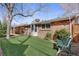 Relaxing backyard featuring a bench, garden bed, and a lush artificial lawn at 2290 E Columbia Pl, Denver, CO 80210