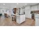 Open kitchen with an island, white cabinets, modern appliances, and hardwood flooring, flowing into the living room at 2290 E Columbia Pl, Denver, CO 80210