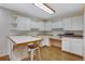 Kitchenette with white cabinets, a functional island, and hardwood floors at 2290 E Columbia Pl, Denver, CO 80210