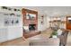 Inviting living room showcasing a brick fireplace, hardwood floors, built-in shelves and easy access to the kitchen at 2290 E Columbia Pl, Denver, CO 80210