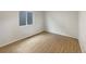 Bedroom featuring wood floors, white walls, and a window providing natural light at 4670 Quandary Peak St, Brighton, CO 80601