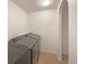 Laundry room featuring tile floors, washer, dryer, and shelving at 4670 Quandary Peak St, Brighton, CO 80601
