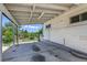 A covered back porch with weathered concrete and white accents, providing a shady spot to sit and relax at 118 S Yates Way, Denver, CO 80219