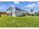 Large backyard featuring green lawn, house with porch, shed, and mature trees, for outdoor activities at 118 S Yates Way, Denver, CO 80219