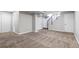 Spacious basement with new carpeting, neutral paint, and multiple access doors at 118 S Yates Way, Denver, CO 80219