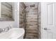 Bathroom featuring a modern shower with stylish fixtures, decorative tiled walls and pebble floor at 118 S Yates Way, Denver, CO 80219