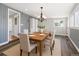 Light dining room featuring modern lighting, a table set for six, and wood floors at 118 S Yates Way, Denver, CO 80219