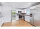 Bright kitchen with stainless steel appliances, white cabinetry, granite countertops, and hardwood floors at 118 S Yates Way, Denver, CO 80219