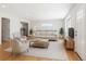 Bright living room featuring wood floors, modern furniture, and a view into the kitchen at 118 S Yates Way, Denver, CO 80219