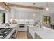 Modern kitchen with white cabinets, a large island, and wooden beams at 1655 S Marion, Denver, CO 80210