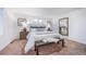 Bright main bedroom with a large bed, bench, and mirror at 3987 N Riviera Ct, Aurora, CO 80019