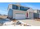 Two-story home with blue siding, red door, and a two-car garage at 3987 N Riviera Ct, Aurora, CO 80019