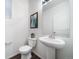 Clean powder room with pedestal sink, toilet, and framed art at 3987 N Riviera Ct, Aurora, CO 80019