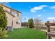 A home's backyard features green artificial turf grass, a wooden fence, and partial view of home's exterior at 12798 Ivy St, Thornton, CO 80602