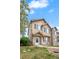 Charming home featuring stone accents, neutral stucco, manicured lawn, and blooming tree at 12798 Ivy St, Thornton, CO 80602