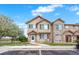 Charming townhome featuring a stone facade, well-maintained landscaping, and a lovely flowering tree at 12798 Ivy St, Thornton, CO 80602