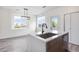 Bright kitchen featuring modern island, stylish sink, updated finishes, and natural light from a large window at 12798 Ivy St, Thornton, CO 80602